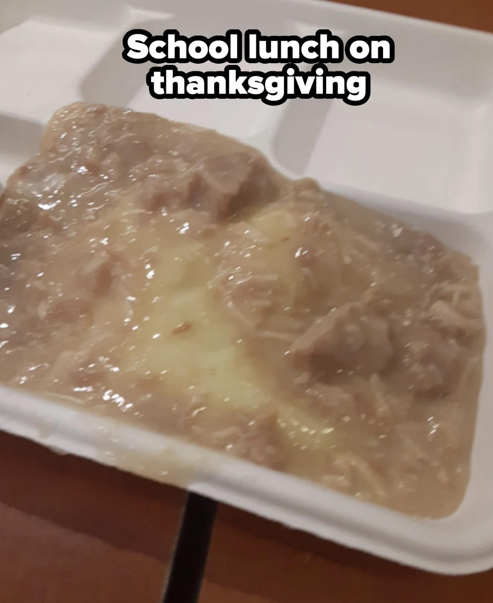 A close-up of a takeaway food container with a portion of mashed potatoes covered in a thick, chunky gravy
