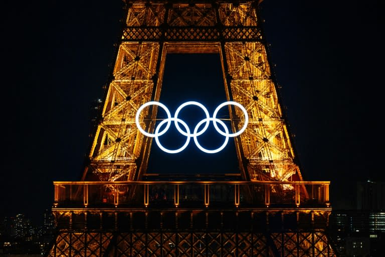 Los aros olímpicos en la Torre Eiffel de París antes de los tradicionales fuegos artificiales del Día de la Fiesta Nacional francesa, el 14 de julio de 2024 (Dimitar DILKOFF)