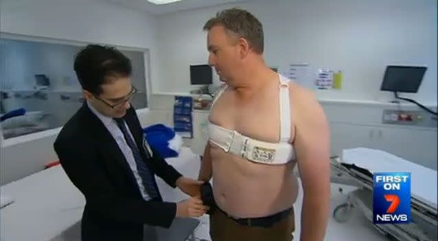 Dr Hendrik Zimmet fits Shane Amyl with the life-saving vest. Photo: 7 News