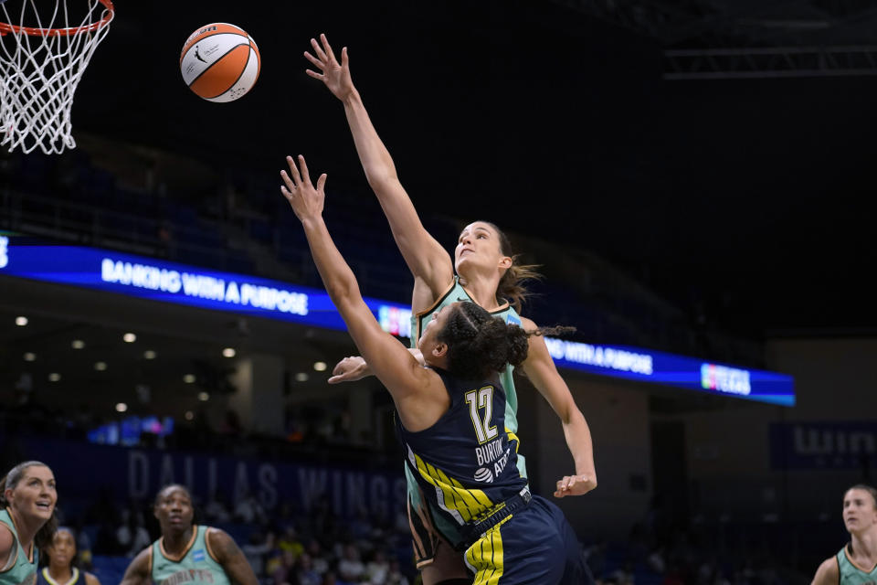 Dallas Wings guard Veronica Burton (12) shoots as New York Liberty guard Rebecca Allen, rear, defends during the first half of a WNBA basketball game in Arlington, Texas, Wednesday, Aug. 10, 2022. (AP Photo/Tony Gutierrez)