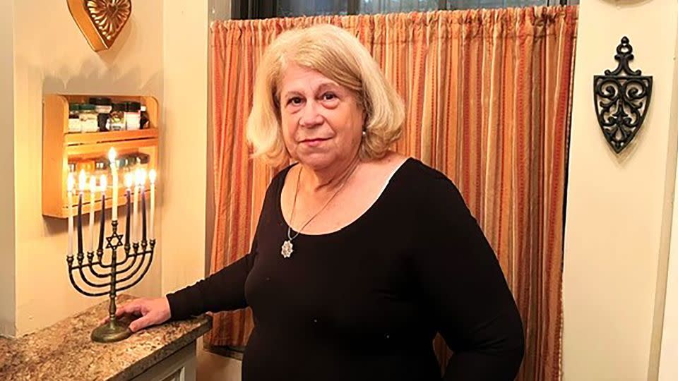 Jean Joachim stands with her menorah near a closed window in the kitchen of her New York home. - Courtesy Jean C. Joachim