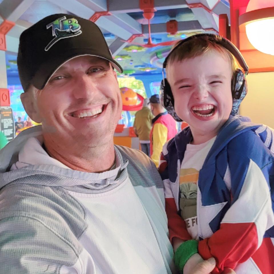 Mike Taylor of Tampa, Fla., and his 7-year-old son, Raylan, who has Joubert Syndrome, are pictured at the Alien Swirling Saucers ride at Hollywood Studios' Toy Story Land.