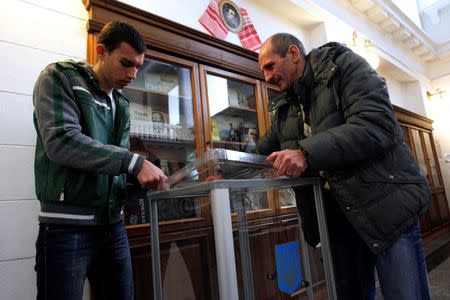 Election commission workers install a ballot box at a polling station in Kiev, October 25, 2014. REUTERS/Valentyn Ogirenko