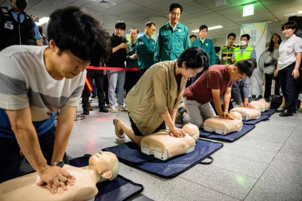 Seoul Mayor Oh Se-hoon (top centre) watches as people receive CPR training while practicing on dummys during a civil defence drill against possible artillery attacks by North Korea, in a subway station in Seoul on 23 August 2023 (AFP via Getty Images)