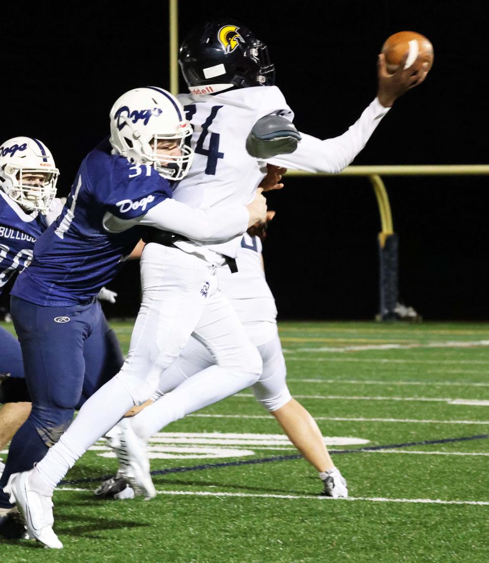 Rockland's Joe Earner pressures St. Mary's quarterback Tyler Guy during a game at Walpole High School on Friday, Nov. 18, 2022.   
