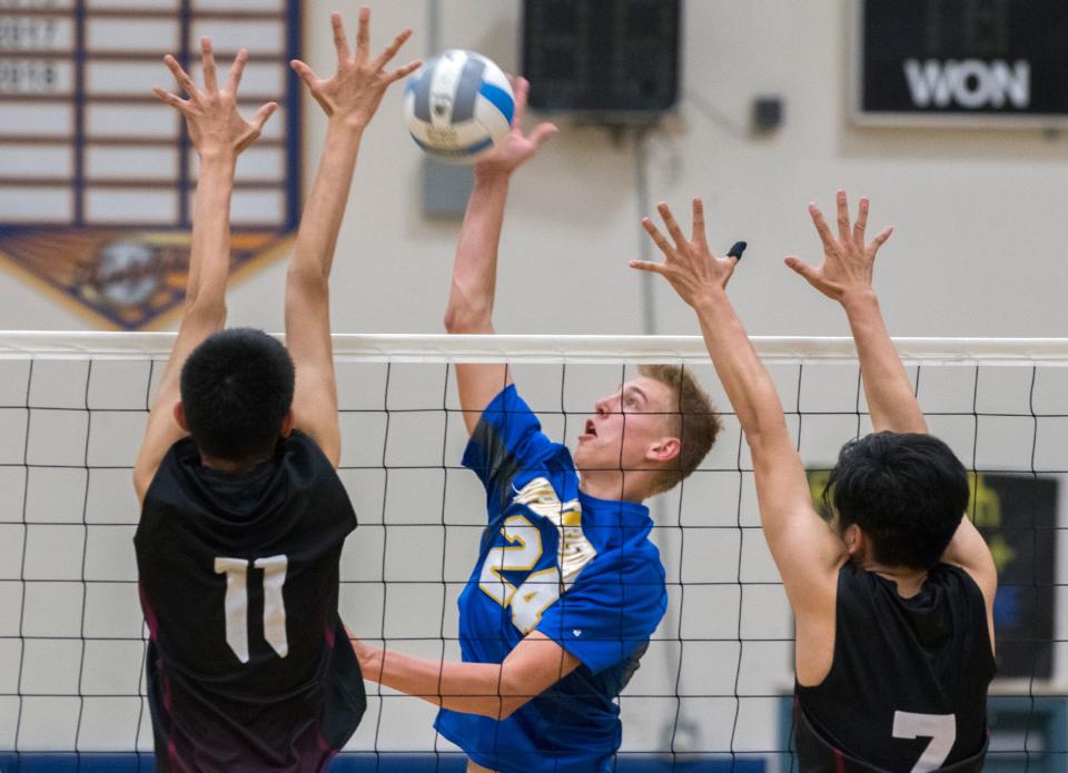 Ripon Christian's Jacob Van Groningen spikes the ball between West Campus' Tannon Phan, left, and Mitch Zheng during a boys volleyball playoff game at Ripon Christian, May 18, 2019.