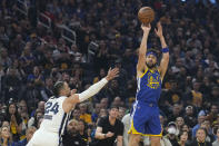Golden State Warriors guard Klay Thompson (11) shoots next to Memphis Grizzlies forward Dillon Brooks (24) during the first half of Game 6 of an NBA basketball Western Conference playoff semifinal in San Francisco, Friday, May 13, 2022. (AP Photo/Tony Avelar)