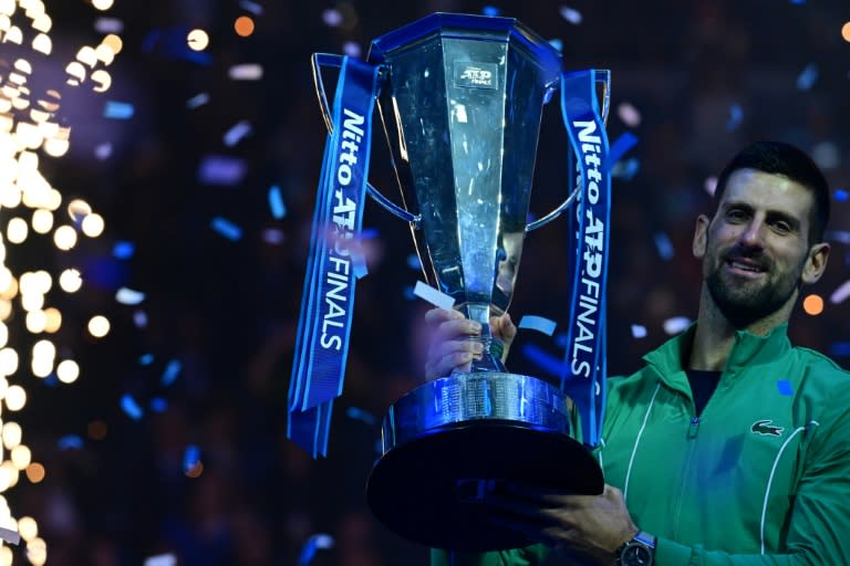 Le Serbe Novak Djokovic pose avec le trophée du Masters ATP après sa victoire en finale contre l'Italien Jannik Sinner, à Turin le 19 novembre 2023. (Tiziana FABI)