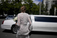 Anna Karpenko heads to the limousine after marrying Denys Voznyi in Kyiv, Ukraine, Wednesday, June 15, 2022. A growing number of couples in Ukraine are speedily turning love into matrimony because of the war with Russia. Some are soldiers, marrying just before they head off to fight. Others are united in determination that living and loving to the full are more important than ever in the face of death and destruction. (AP Photo/Natacha Pisarenko)