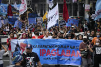 Former lawmaker and activist Satur Ocampo, center, leads other protesters as they march near the Malacanang presidential palace to commemorate International Human Rights Day, Saturday, Dec. 10, 2022, in Manila, Philippines. Hundreds of people marched in the Philippine capital on Saturday protesting what they said was a rising number of extrajudicial killings and other injustices under the administration of President Ferdinand Marcos Jr. (AP Photo/Aaron Favila)