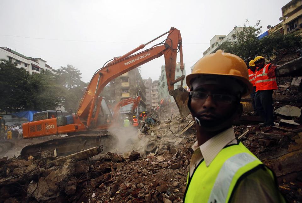 Rescue crews search for survivors at the site of a collapsed residential building in Mumbai