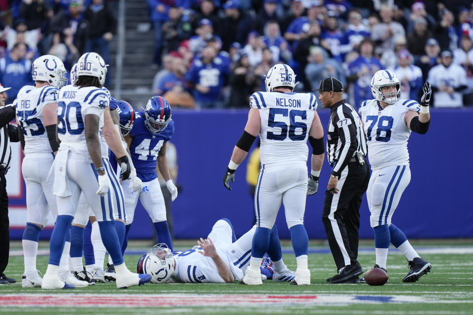 Players gather around Indianapolis Colts quarterback Nick Foles after he was injured during the first half of an NFL football game against the New York Giants, Sunday, Jan. 1, 2023, in East Rutherford, N.J. (AP Photo/Bryan Woolston)