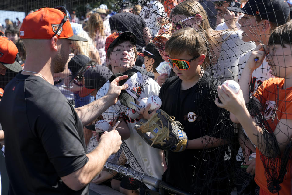 San Francisco Giants pitcher Daulton Jefferies signs autographs prior to a spring training baseball game against the San Diego Padres Saturday, March 2, 2024, in Scottsdale, Ariz. Jefferies is trying to come back from a second Tommy John surgery at age 28. (AP Photo/Ross D. Franklin)