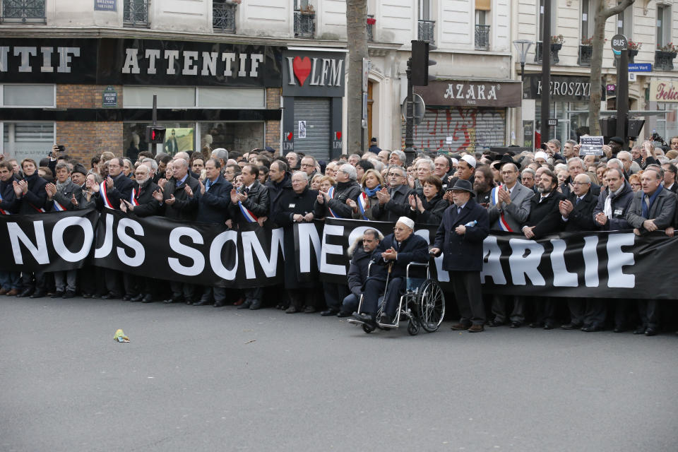 French officials, with Paris mosque rector Dalil Boubakeur in a wheelchair, march in Paris, France, Sunday, Jan. 11, 2015. A rally of defiance and sorrow, protected by an unparalleled level of security, on Sunday will honor the 17 victims of three days of bloodshed in Paris that left France on alert for more violence. (AP Photo/Francois Mori)