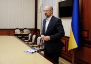 Ukraine's Prime Minister Shmygal buttons his jacket after an interview in Kiev