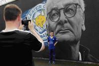 A boy poses for a photograph in front of a mural of Leicester City manager Claudio Ranieri, by Artist Richard Wilson, ahead of Leicester City's away soccer match against Manchester United, Leicester, Britain May 1, 2016 REUTERS/Eddie Keogh