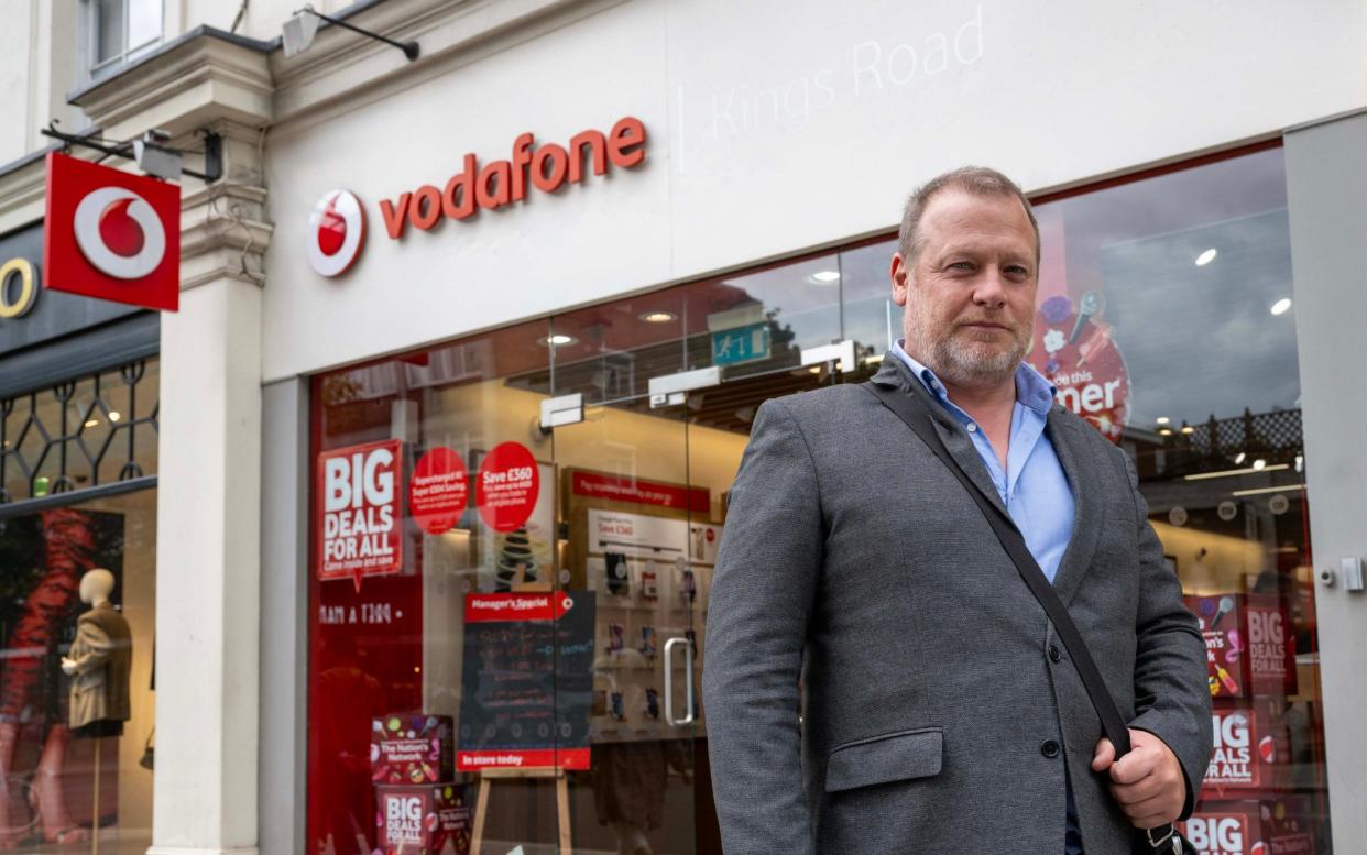 Image shows George Chesterton outside a phone shop