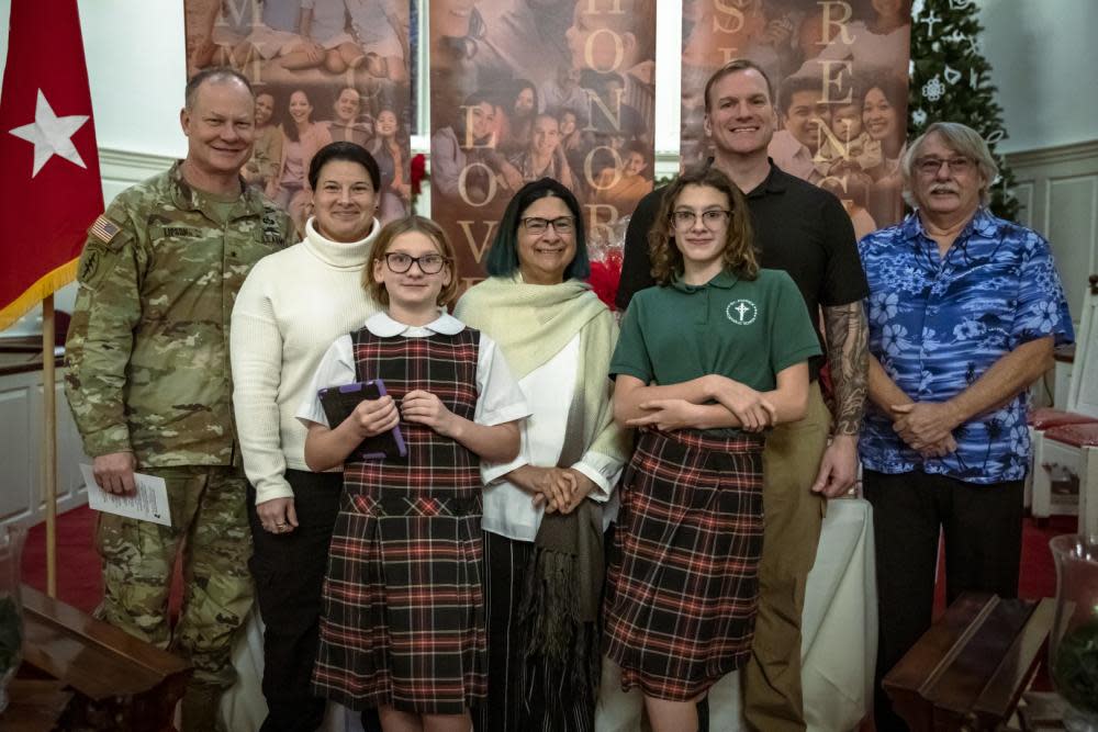 U.S. Army Brig. Gen. Derek N. Lipson, 1st Special Forces Command deputy commanding general, (left) poses with the Burlee family, winners of the Fort Bragg 2022 Family of the Year, on Dec. 1.