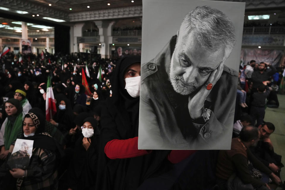 A mourner holds a poster of the late Revolutionary Guard Gen. Qassem Soleimani, who was killed in Iraq in a U.S. drone attack in 2020, during a ceremony marking anniversary of his death, at Imam Khomeini Grand Mosque in Tehran, Iran, Tuesday, Jan. 3, 2023. Iran's President Ebrahim Raisi on Tuesday vowed to avenge the killing of the country's top general on the third anniversary of his death, as the government rallied its supporters in mourning amid months of anti-government protests. (AP Photo/Vahid Salemi)