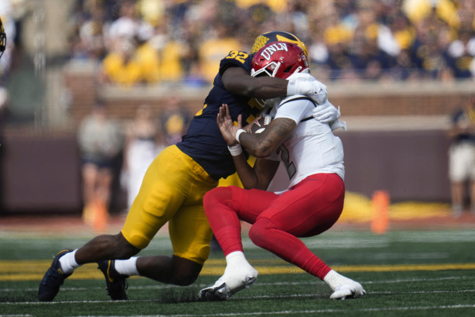 Michigan defensive end Jaylen Harrell (32) sacks UNLV quarterback Doug Brumfield (2) in the first half of an NCAA college football game in Ann Arbor, Mich., Saturday, Sept. 9, 2023. (AP Photo/Paul Sancya)