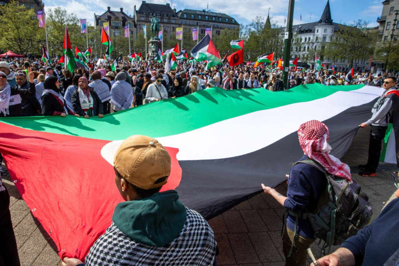 Protesters hold a giant Palestinian flag during a Pro-Palestine rally before the final of the Eurovision Song Contest (ESC) 2024. Jens Büttner/dpa