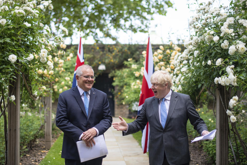 Britain's Prime Minister Boris Johnson, right, walks with Australian Prime Minister Scott Morrison after their meeting, in the garden of 10 Downing Streeet, in London, Tuesday June 15, 2021. Britain and Australia have agreed on a free trade deal that will be released later Tuesday, Australian Trade Minister Dan Tehan said. (Dominic Lipinski/Pool Photo via AP)