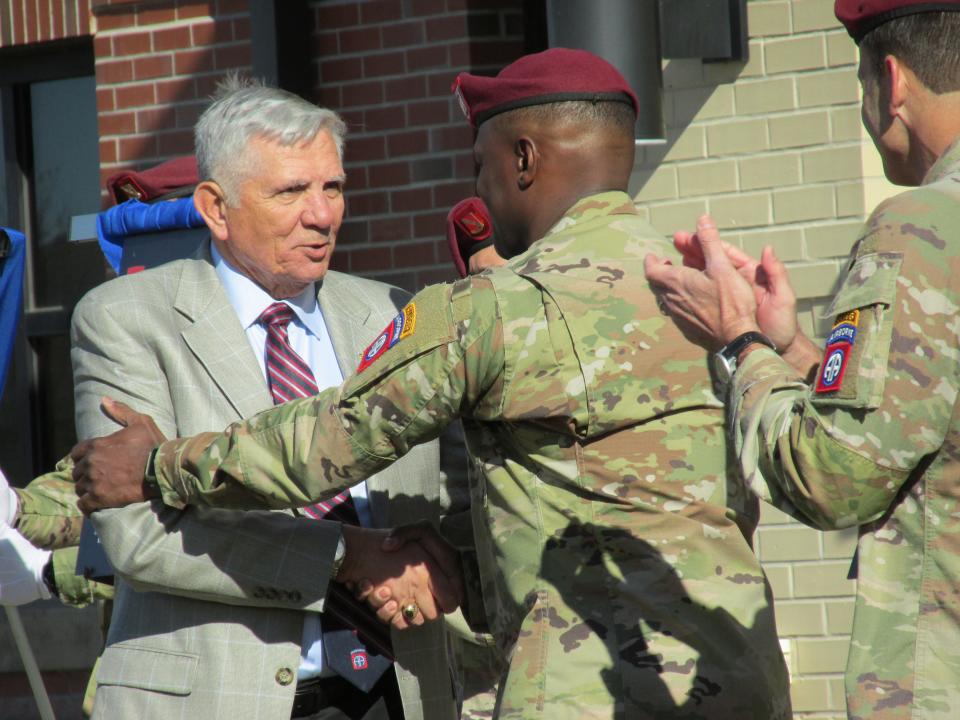 Command Sgt. Maj. David Pitt (center) congratulates retired Command Sgt. Maj. Steven R. Slocum (far left) on Slocum's induction into the 82nd Airborne Division Hall of Fame, as Maj. Gen. Christopher Donahue claps, during a Nov. 19, 2021, ceremony at Fort Bragg.