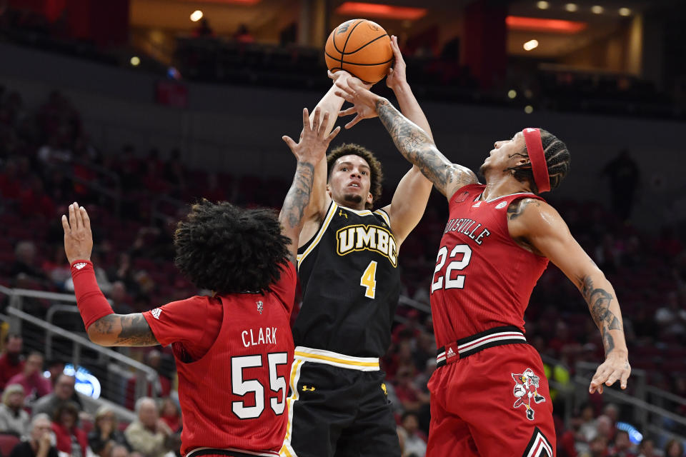 Maryland Baltimore County guard Marlon Short (4) attempts a shot over Louisville guard Tre White (22), and guard Skyy Clark (55) during the first half of an NCAA college basketball game in Louisville, Ky., Monday, Nov. 6, 2023. (AP Photo/Timothy D. Easley)