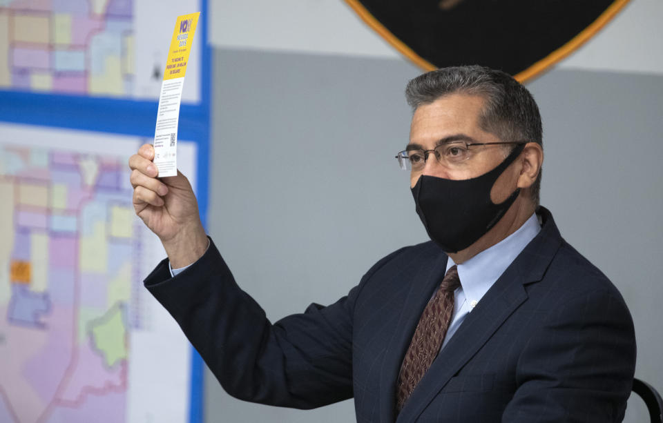 U.S. Department of Health and Human Services (HHS) Secretary Xavier Becerra holds up a flier promoting the Vax Nevada Days lottery after briefing from officials at the Clark County Fire Department Training Facility in Las Vegas Thursday, July 22, 2021. The vaccine lottery awards cash and prizes to Nevada residents who have received the COVID-19 vaccine. (Steve Marcus /Las Vegas Sun via AP)