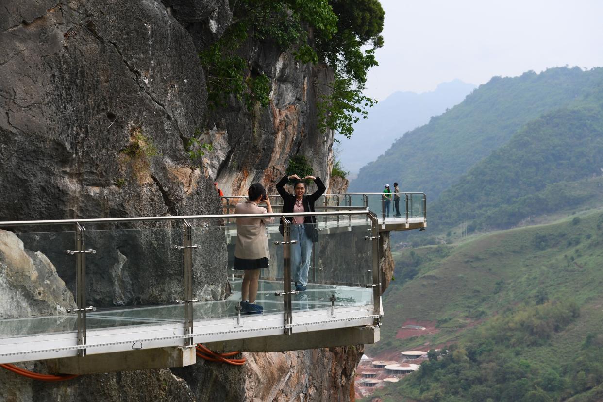 people stand on the Bach Long glass bridge in the Moc Chau district in Vietnam's Son La province