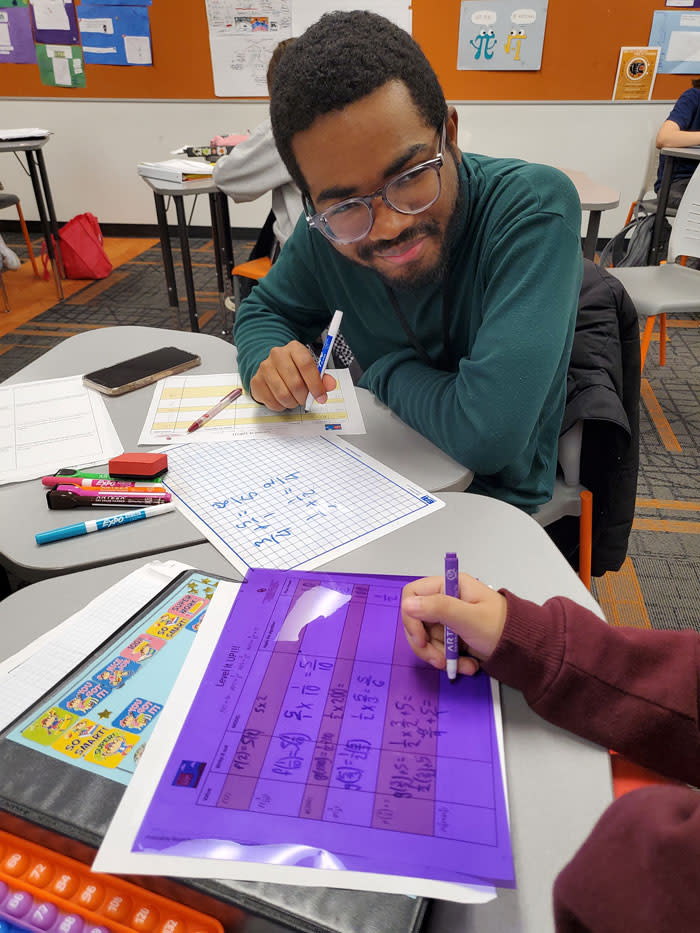 An Oklahoma University tutor works with a 9th grade student on function notation with fractions, using color page covers at the suggestion of veteran educators. Colored sheets can be helpful for students who have ADD/ADHD and dyslexia. (Courtesy of the University of Oklahoma’s Transformative Tutoring Initiative)