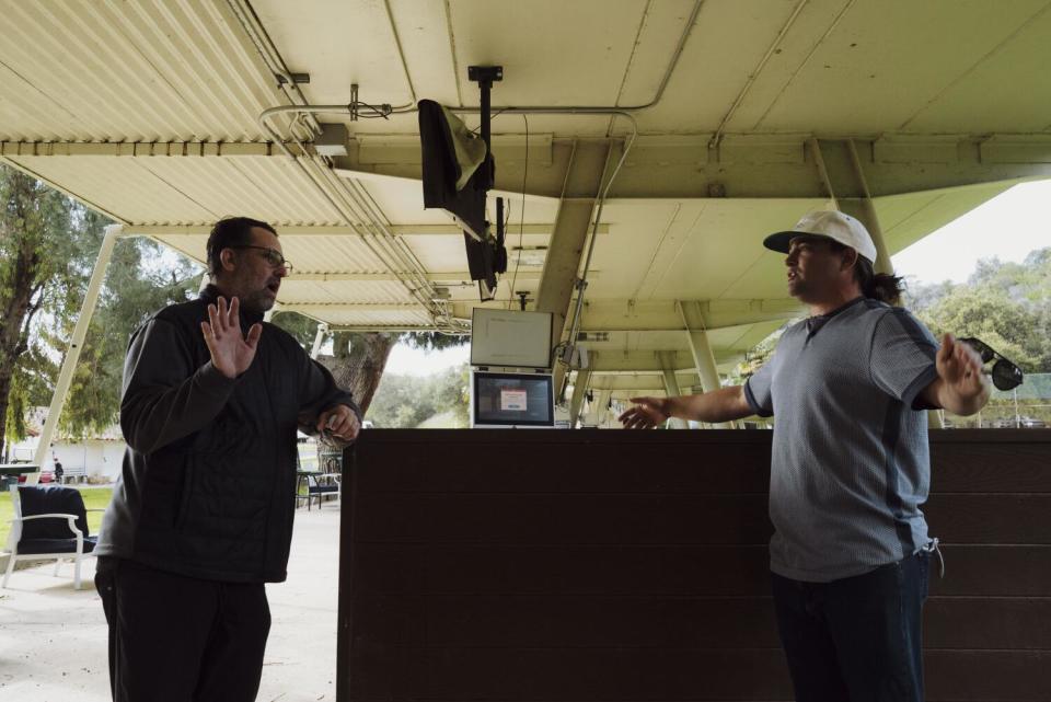 Dave Fink speaks with Paul Nassaney while they both gesture.