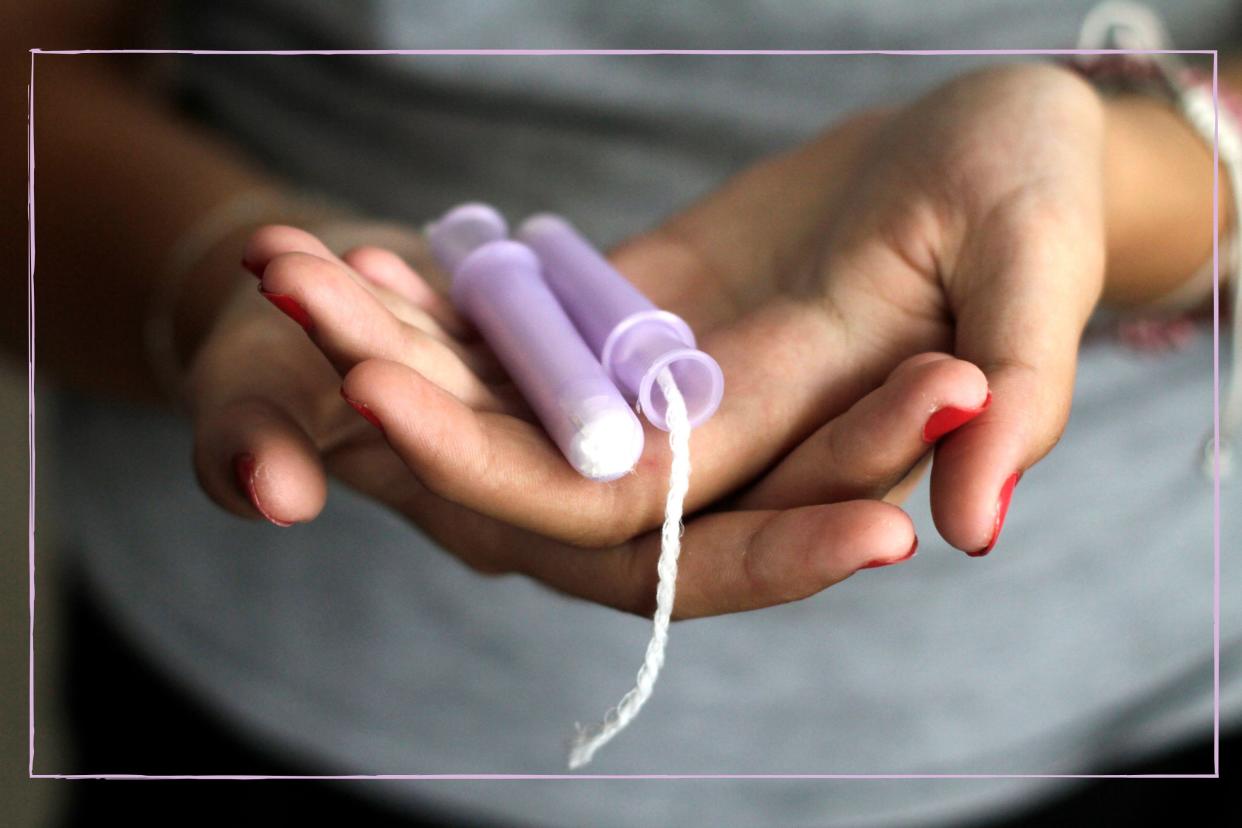  Woman holding tampons in the palms of her hands. 