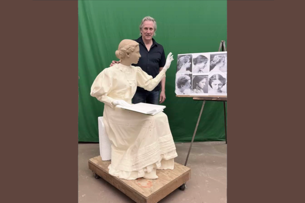 Sculptor poses with a working model of Helen Keller statue.