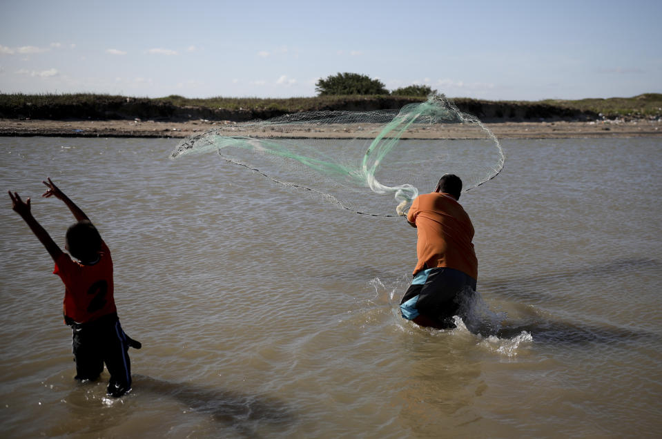 In this Aug. 2, 2019 photo, local tourists fish at in the waters of Playa Bagdad near the border city of Matamoros, Mexico. Besides fishing, contraband has always been here in one form or another: silver, or alcohol during Prohibition. In the 1980s and 90s, marijuana and Colombian cocaine. (AP Photo/Emilio Espejel)