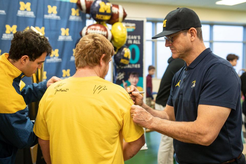 Michigan head coach Jim Harbaugh and wide receiver Jake Thaw sign autographs for Justin Carpenters of Pontiac at C.S. Mott Children's Hospital in Ann Arbor on Friday, Jan. 12, 2024.