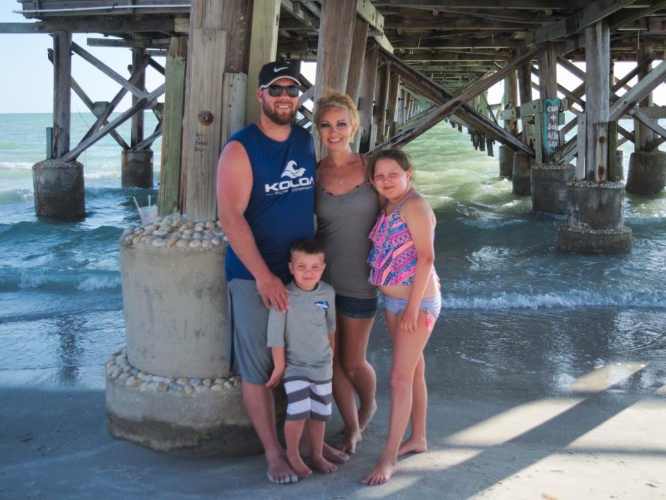 Christine MacIntyre, her husband, and their two kids at the beach.