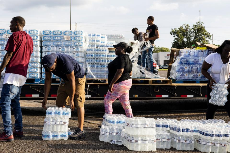 Cases of bottled water are handed out at a Mississippi Rapid Response Coalition distribution site on August 31, 2022 in Jackson, Mississippi. Jackson is experiencing a third day without reliable water service after river flooding caused the main treatment facility to fail. Late Tuesday night, President Joe Biden declared an emergency amid the crisis.