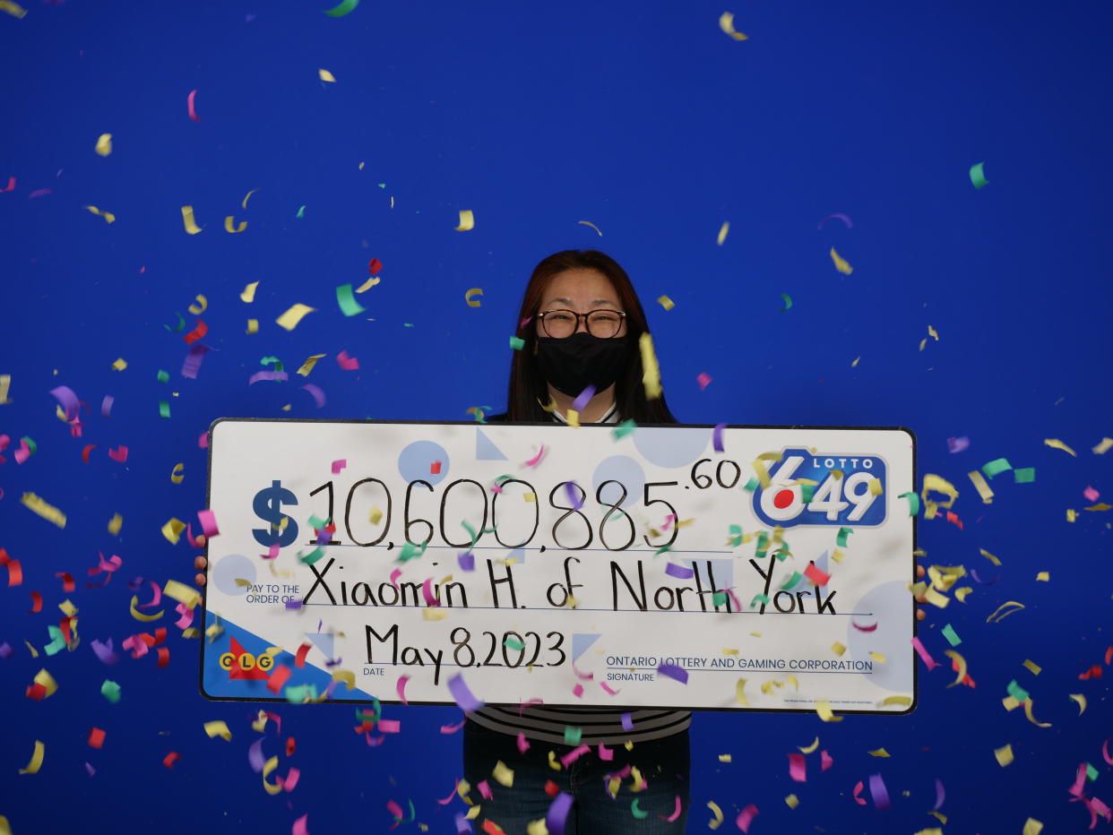 Woman holding a Lotto 6/49 check worth $10.6 million.  