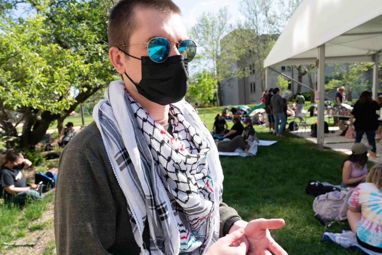 Jam H., a University of Kansas senior studying political science, talks about why they have set up an encampment to protest the ongoing Israel-Hamas war in Gaza on Wednesday in front of Fraser Hall.
