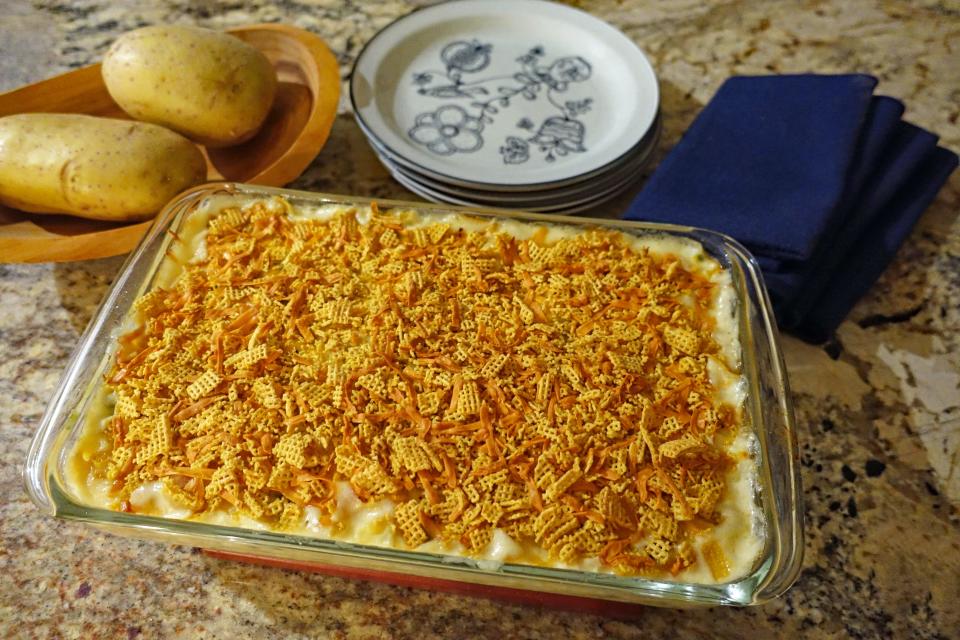 Cheesy potato casserole is topped with a mixture of crushed Corn Chex and smoked cheddar cheese before baking.