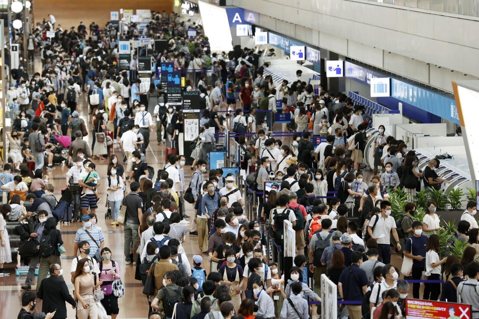 Travelers wearing face masks crowd at Haneda airport in Tokyo Saturday, Sept. 19, 2020, on the first day of the 4-day holiday. (Kyodo News via AP)