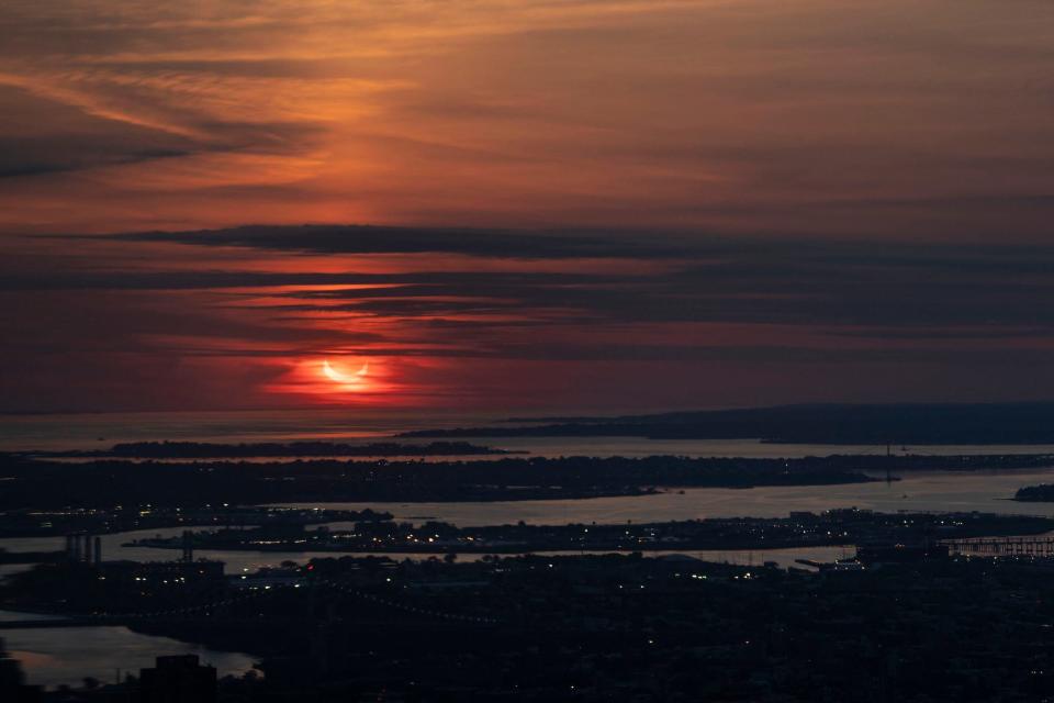 The sun rises partially eclipsed in a view taken from Summit One Vanderbilt (AFP via Getty Images)