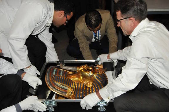 Officials transport the restored mask.