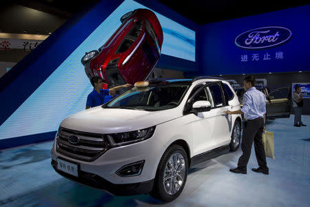 FILE PHOTO - A visitor (R) gets in a Ford Edge SUV at the 13th China (Guangzhou) International Automobile Exhibition in Guangzhou, China November 20, 2015. REUTERS/Tyrone Siu/File Photo