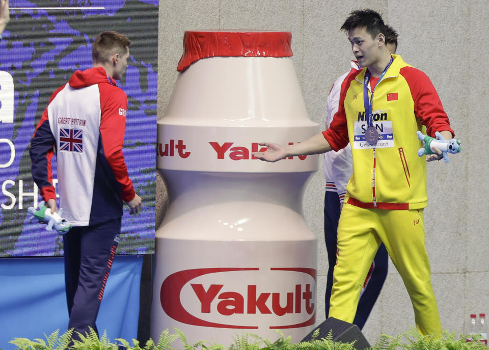 Gold medlaist China's Sun Yang, right, gestures to Britain's bronze medalists Duncan Scott following the medal ceremony in the men's 200m freestyle final at the World Swimming Championships in Gwangju, South Korea, Tuesday, July 23, 2019. (AP Photo/Mark Schiefelbein)