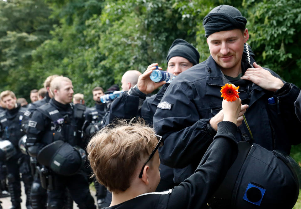 <p>A boy shows his appreciation for the police watching a demonstration pass by on July 8, 2017 in Hamburg, northern Germany as world leaders meet during the G20 summit. (Photo: Odd Andersen/AFP/Getty Images) </p>