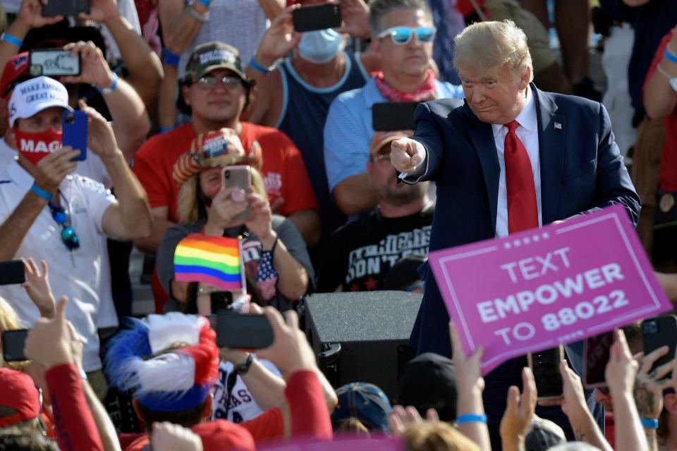 President Donald Trump points to supporters after arriving for a campaign rally at the Ocala International Airport in 2020.