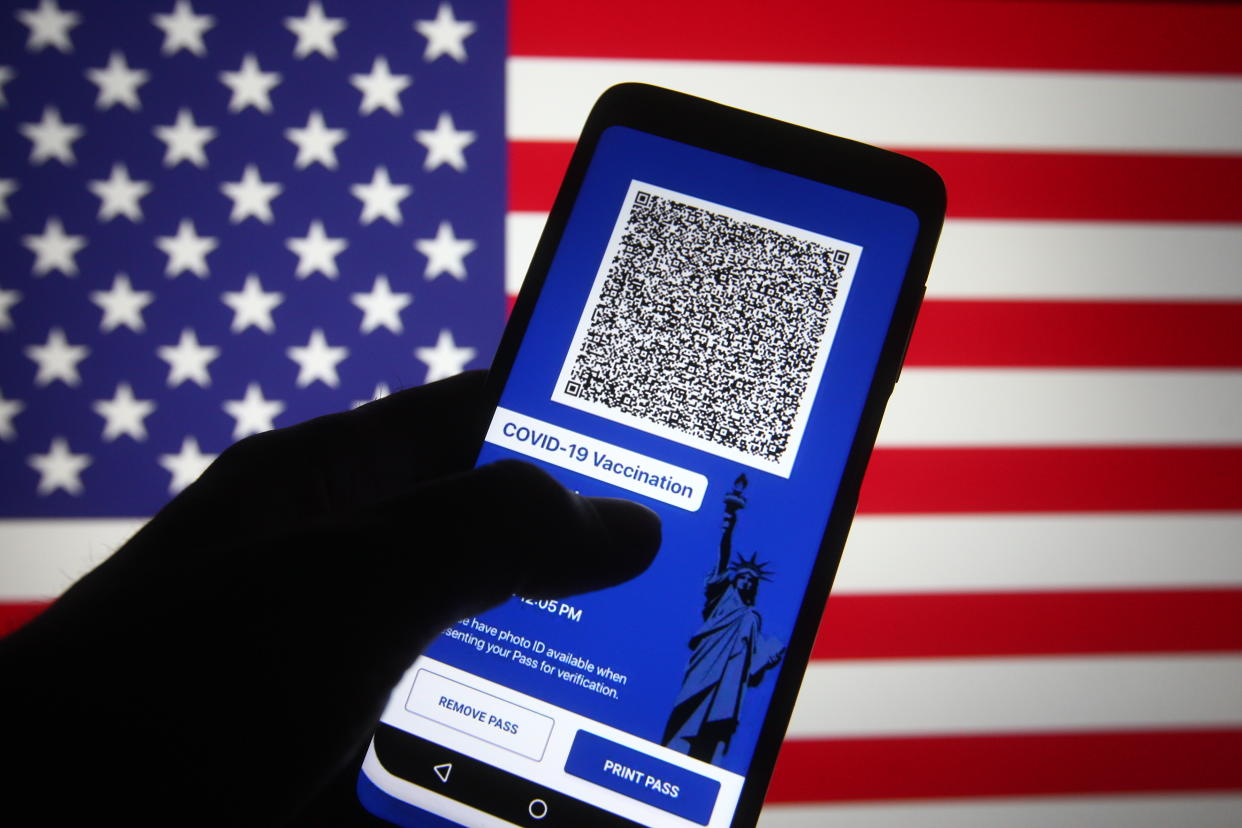 UKRAINE - 2021/03/28: In this photo illustration, Excelsior Pass app which provides digital proof of COVID-19 vaccination or negative test results seen displayed on a smartphone screen in front of the US flag. 
The first COVID-19 vaccine passports' in the US called the Excelsior Pass was launched on Friday in New York, reportedly by the media on 27 March. Excelsior Pass provides digital proof of COVID-19 vaccination or negative test results of three types of passes: COVID-19 Vaccination Pass, COVID-19 PCR Test Pass, and COVID-19 Antigen Test Pass. (Photo Illustration by Pavlo Gonchar/SOPA Images/LightRocket via Getty Images)