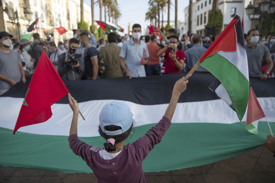 A young girl waves a Moroccan and a Palestinian flag during a protest against normalizing relations with Israel, in Rabat, Morocco, Friday, Sept. 18, 2020. Despite a government ban on large gatherings aimed at preventing the spread of the coronavirus, scores of Moroccans staged a protest outside parliament building in the capital Rabat on Friday to denounce Arab normalization agreements with Israel. (AP Photo/Mosa'ab Elshamy)